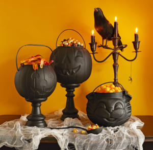 pumpkin cauldrons filled with halloween candy for halloween party table