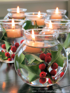 Velas flotantes y Holly Berry en un recipiente de vidrio