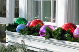 outdoor window box with christmas ornaments and evergreen