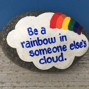 rock painted with Be a rainbow in someone else's cloud