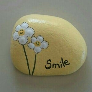 rock painted with flowers and smile
