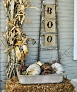 Vintage Fall Porch with ladder, hay bale, dried corn and tub of pumpkins