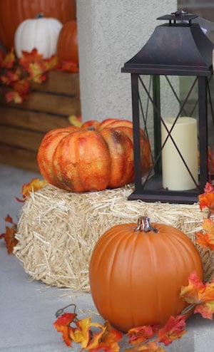 Fall Hay porch Decor idea with fall garland, lantern and pumpkins