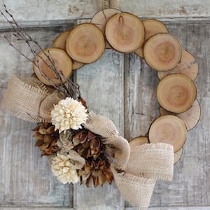 fall wood slice wreath with a burlap bow and pinecones