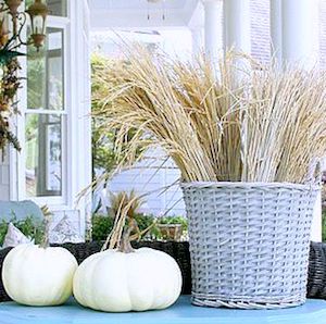 Chic Neutral Fall Porch with wicker basket of wheat and white pumpkins