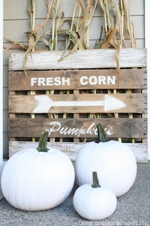 wood pallet fall sign with dried corn and white pumpkins