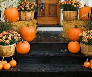 Escaleras de otoño porche con crisantemos, pacas de heno y calabazas de varios tamaños 