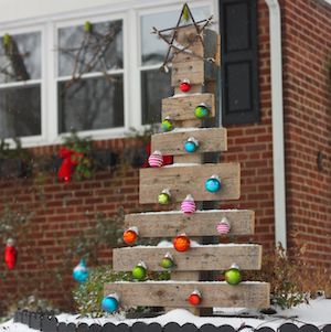 Árbol de paletas de madera con adornos navideños