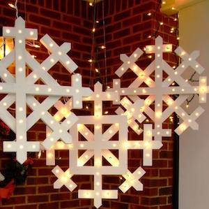 Copos de nieve de madera al aire libre con luces navideñas