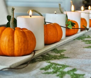 mini pumpkins and candles on a candle tray