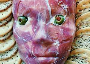 Creepy Prosciutto Face Halloween Cheese Ball with olive eyes