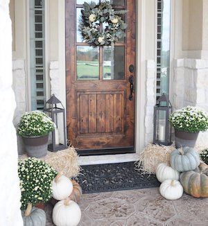 Porche delantero de otoño con calabazas y calabazas