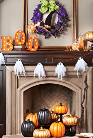 lassic Halloween Mantel with ghost garland and halloween wreath above fireplace