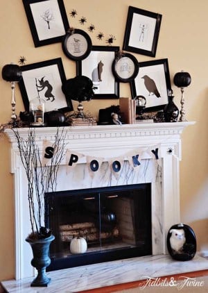 black and white Halloween decor with picture frames above mantel