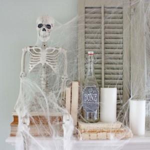 Ghostly Halloween Mantel Decor with spider webs and skeleton