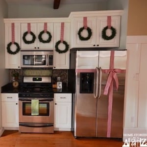 small apartment kitchen decorated with mini Wreaths on cabinets and Bow on Refrigerator 