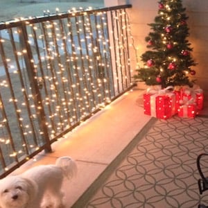 Balcón de Navidad iluminado con pequeño árbol de Navidad y regalos