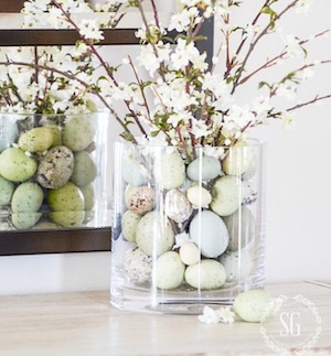 white flowers in a vase with Easter eggs on table