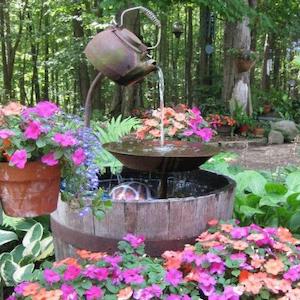 Fuente de tetera rodeada de flores 