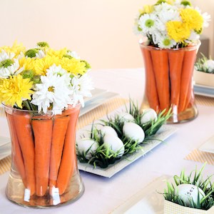 Carrots in a vase with flowers and easter Eggs in Grass table decor