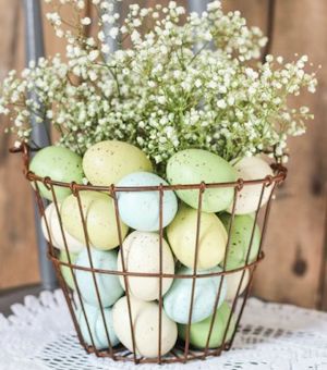 wire basket filled with pastel eggs and baby's breath