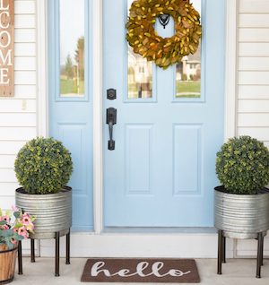 front porch with wreath, planters and welcome mat