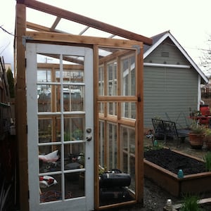 greenhouse out of unfinished cedar, antique windows and our old front door
