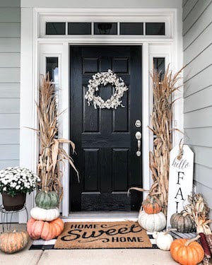 fall front porch decor with corn stalks, heirloom pumpkins and a hello fall sign