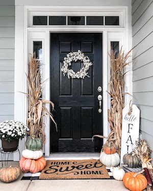 calabazas y tallos de maíz secos a ambos lados de la puerta