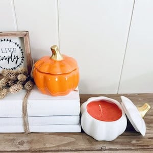 pumpkin candles on a stack of books.