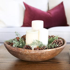 wooden bowl with evergreen, pinecones and candles