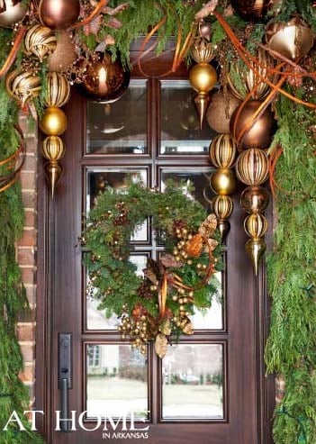 gold ornaments and evergreen garland and wreath