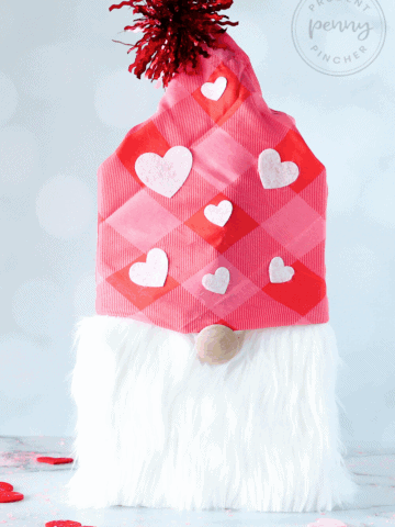 Gnome Valentine craft on a tabletop with scattered heart confetti,