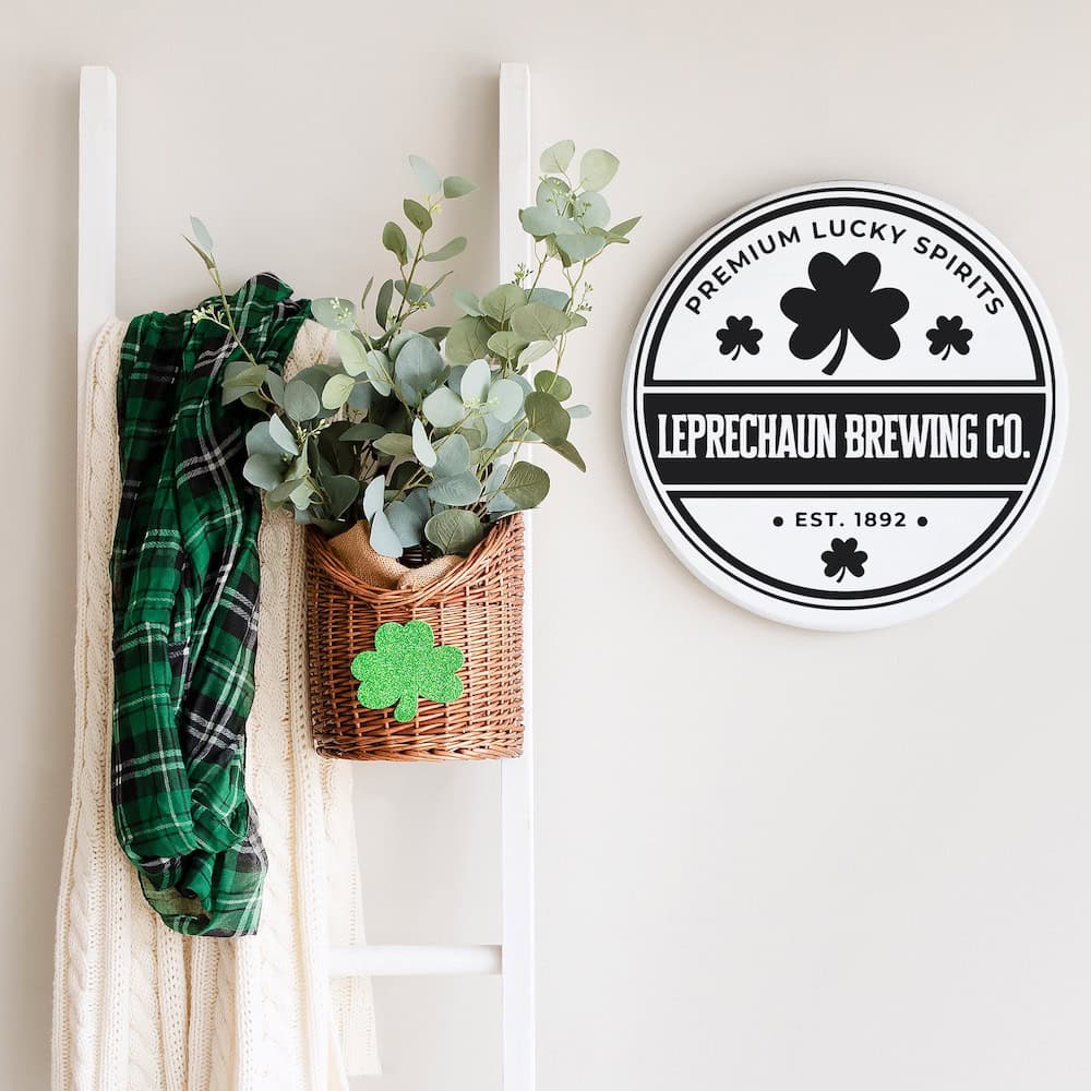 wall decor with round Leprechaun Brewing Co. sign on neutral wall beside blanket ladder