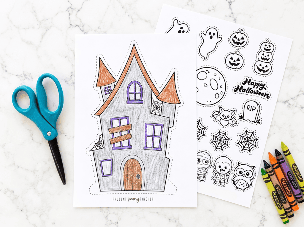 Colored haunted house printable with scissors, crayons, and Halloween character cutout sheet