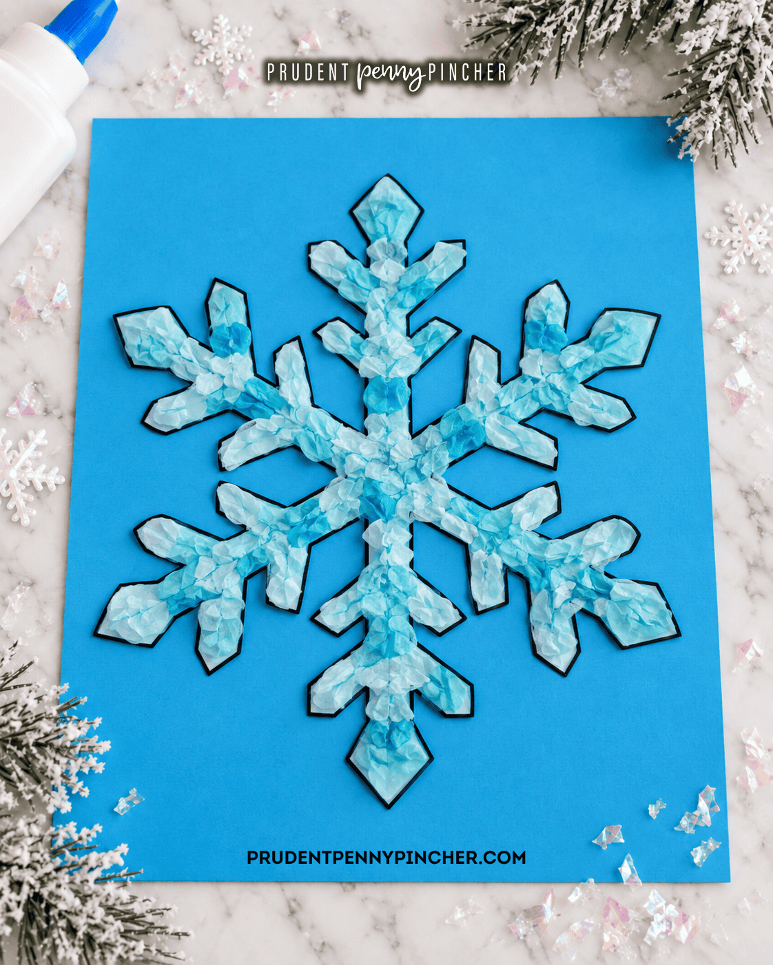 Blue crumpled tissue paper snowflake craft made with a free printable snowflake template on blue cardstock.